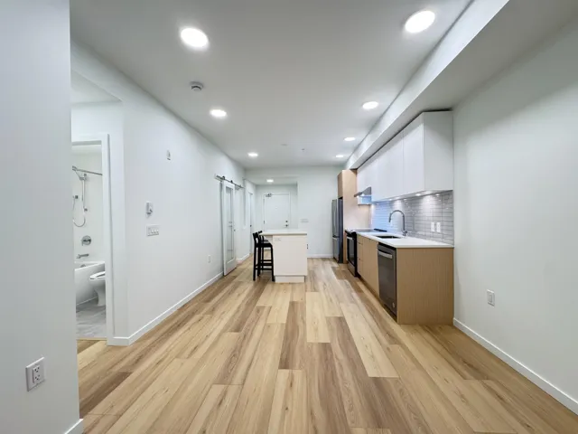 Kitchen with white cabinetry, modern cabinets, a kitchen breakfast bar, a kitchen island, and light wood-type flooring