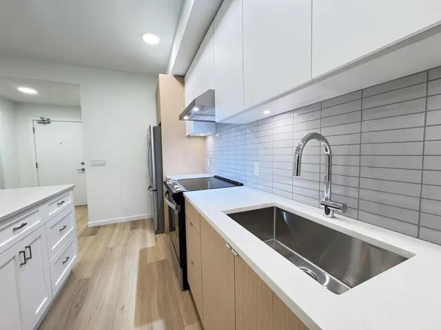 Kitchen featuring black / electric stove, white cabinetry, modern cabinets, under cabinet range hood, and recessed lighting