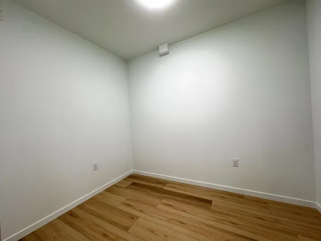 Unfurnished room featuring light wood finished floors and baseboards