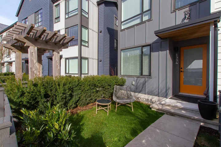 Property entrance featuring a yard, board and batten siding, and a pergola