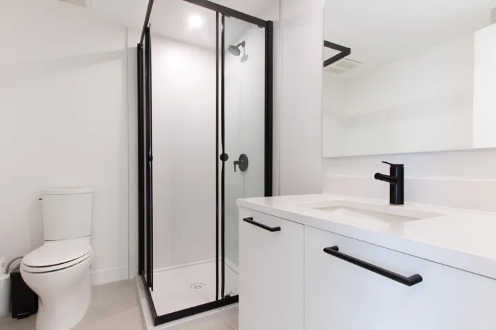 Bathroom with vanity, a shower stall, toilet, and visible vents