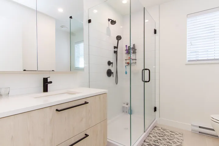 Bathroom featuring toilet, a shower stall, tile patterned flooring, a baseboard radiator, and vanity