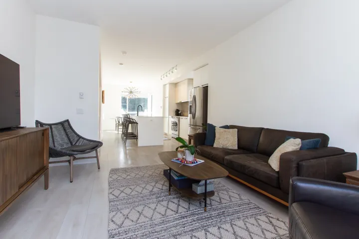 Living area with light wood-style flooring and track lighting
