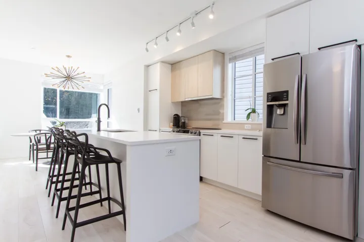 Kitchen featuring modern cabinets, stainless steel refrigerator with ice dispenser, and a sink