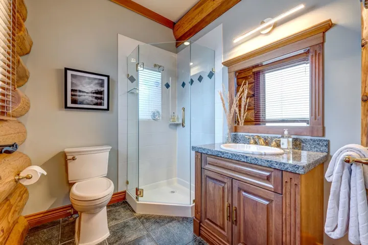 Full bath featuring a shower stall, vanity, healthy amount of natural light, and beam ceiling