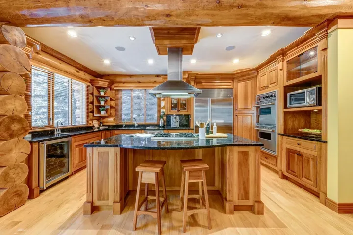 Kitchen featuring wine cooler, open shelves, appliances with stainless steel finishes, light wood-style flooring, and a kitchen island