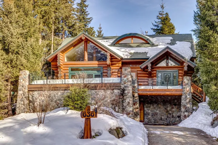 Cabin featuring log exterior and stone siding