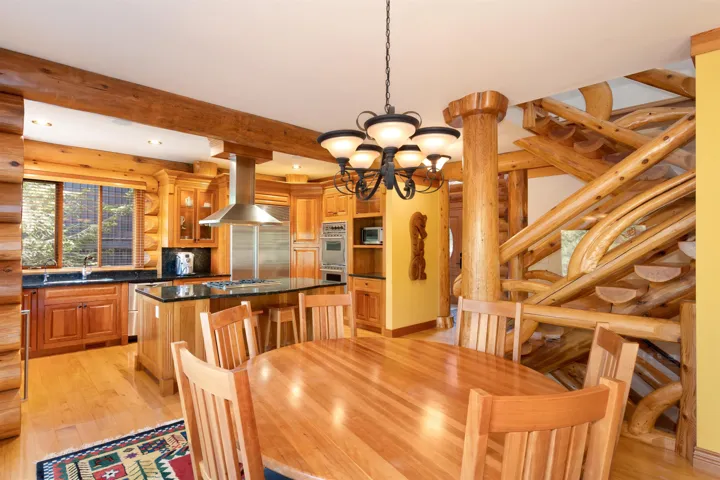 Dining area with light wood-style flooring, a chandelier, recessed lighting, and beamed ceiling