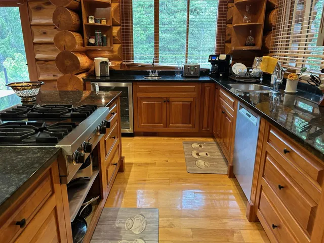 Kitchen with range, open shelves, dishwashing machine, and beverage cooler