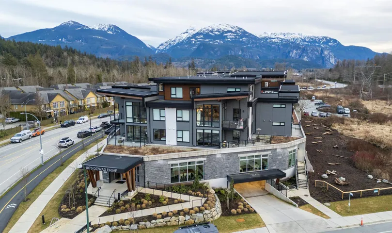 Exterior space with a balcony, stone siding, roof mounted solar panels, and a mountain view