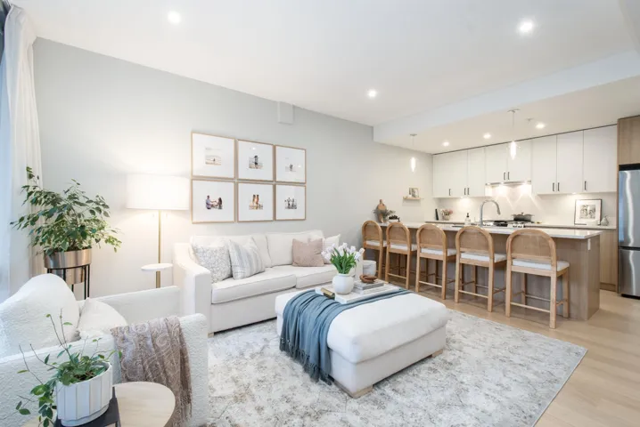 Living area with light wood-style flooring and recessed lighting