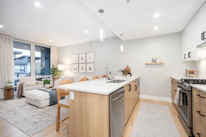 Kitchen featuring stainless steel appliances, a peninsula, a sink, a kitchen breakfast bar, and modern cabinets