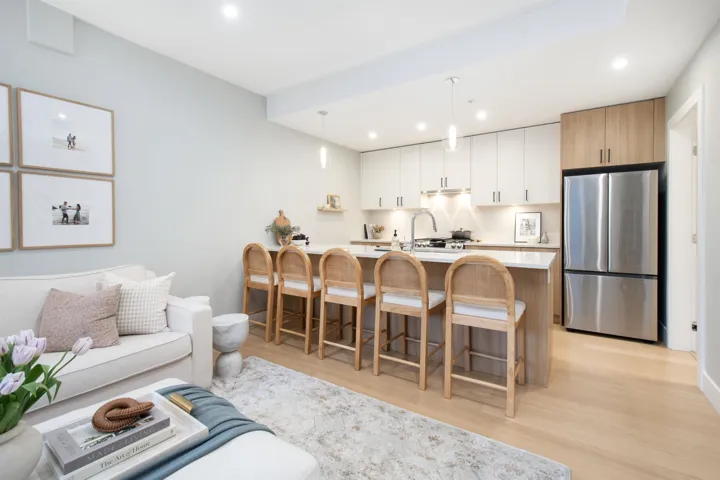 Kitchen featuring freestanding refrigerator, light countertops, light wood finished floors, and a breakfast bar area