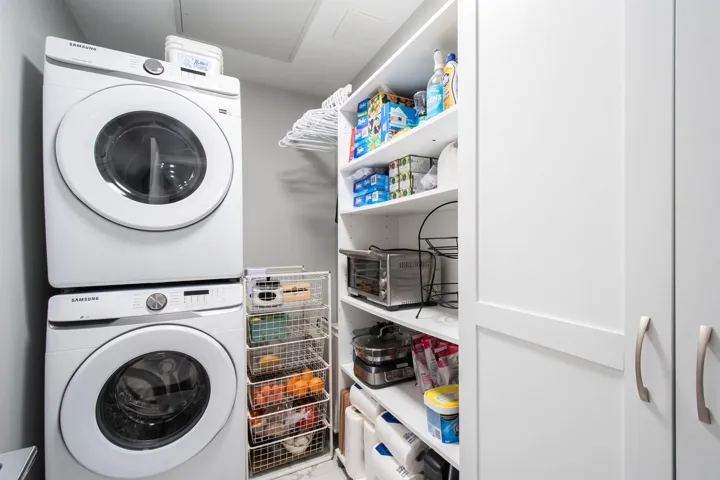 Laundry room featuring stacked washer / drying machine and laundry area