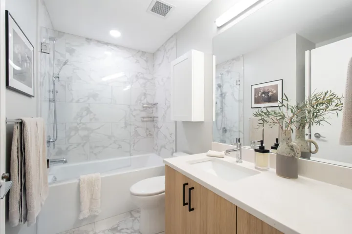 Full bath featuring shower / bath combination, visible vents, toilet, marble finish floor, and vanity