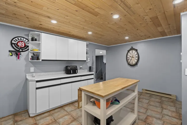 Kitchen featuring open shelves, white cabinets, recessed lighting, a baseboard heating unit, and wooden ceiling