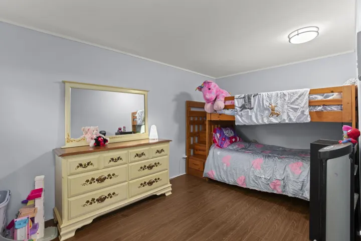Bedroom featuring crown molding and dark wood-style flooring