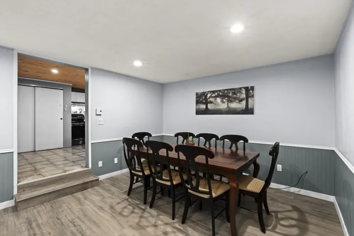 Dining room featuring wood finished floors, recessed lighting, and wainscoting