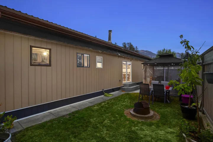 View of side of property featuring a gazebo, a patio area, and a lawn