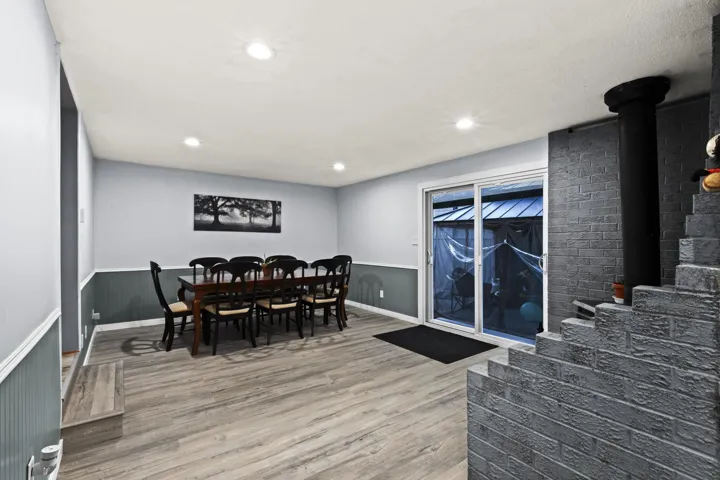 Dining room featuring light wood-style flooring, recessed lighting, and wainscoting