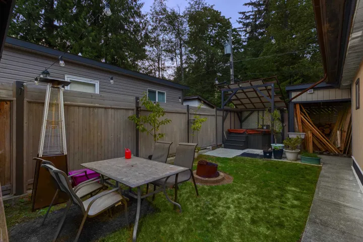 Fenced backyard with a hot tub, a patio, and outdoor dining space
