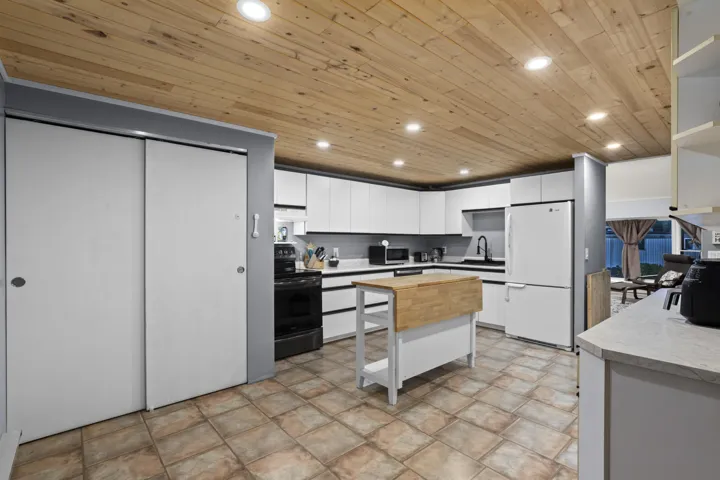 Kitchen featuring white cabinets, recessed lighting, open shelves, wood ceiling, and freestanding refrigerator