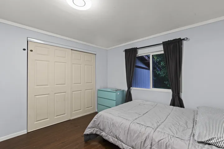 Bedroom featuring dark wood-style flooring, a closet, and ornamental molding