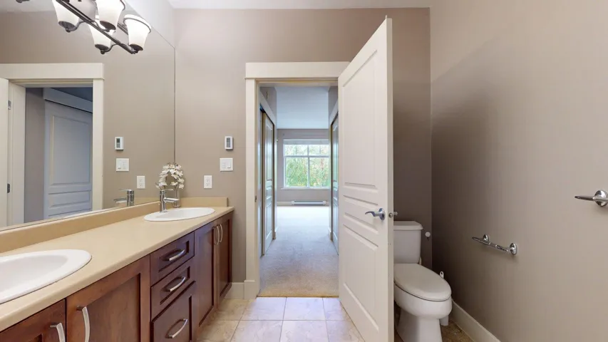 Full bath featuring double vanity, light tile patterned floors, and light colored carpet