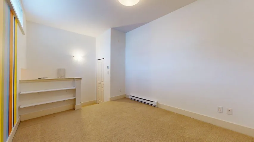 Spare room with light colored carpet and baseboard heating