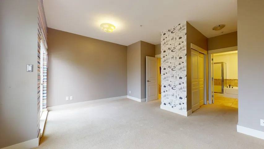 Unfurnished room featuring light colored carpet and baseboards