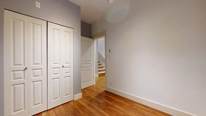 Unfurnished bedroom featuring light wood-style floors and a closet