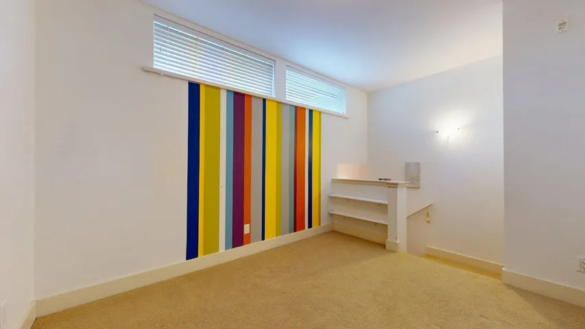 Spare room featuring carpet flooring and baseboards