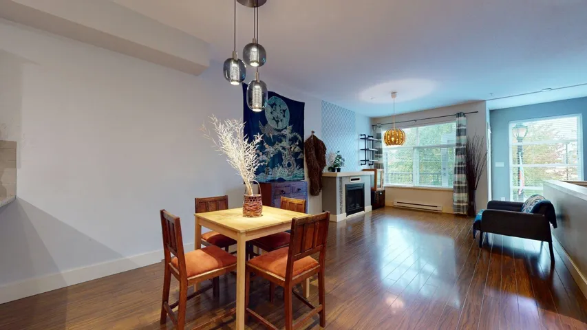 Dining room featuring a fireplace, dark wood-style floors, and a baseboard radiator