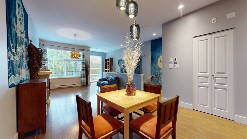 Dining area featuring wood finished floors, a baseboard heating unit, and recessed lighting