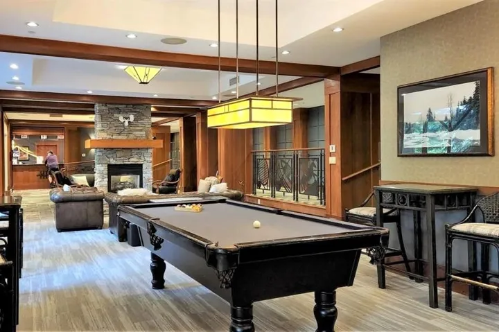 Playroom featuring recessed lighting, billiards, a stone fireplace, and wood finished floors