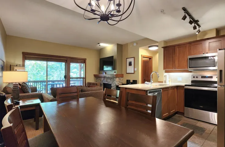 Kitchen with appliances with stainless steel finishes, open floor plan, a chandelier, and light countertops