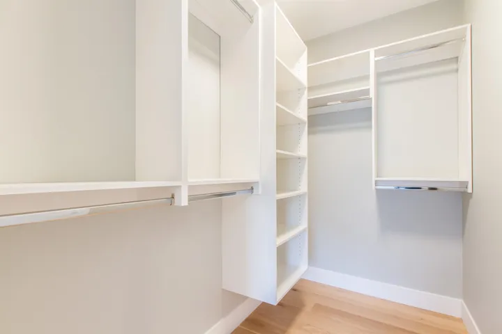 Primary Bedroom walk in closet featuring wood finished floors