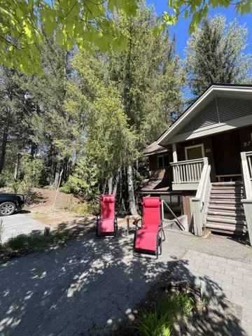 Rustic cabin exterior featuring a brown facade and green trim, set among mature trees