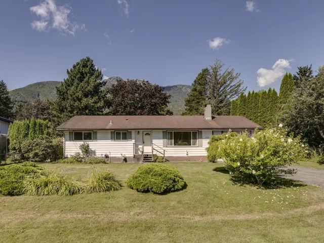 Single story home with a front lawn, a mountain view, a chimney, and entry steps
