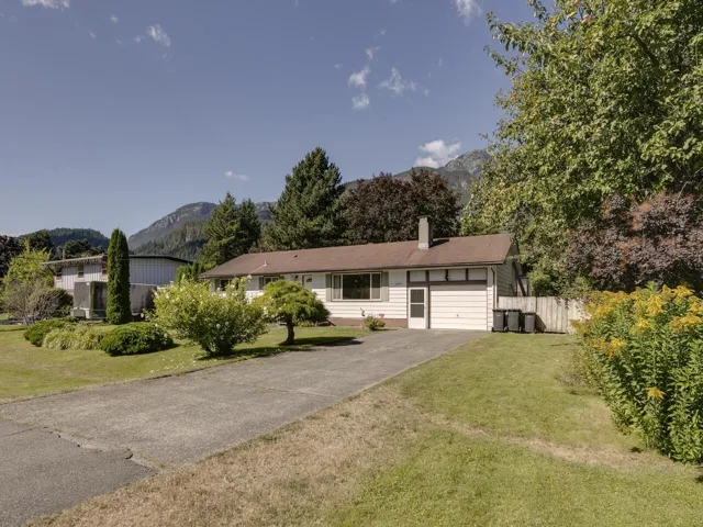 Single story home featuring a mountain view, a chimney, and asphalt driveway