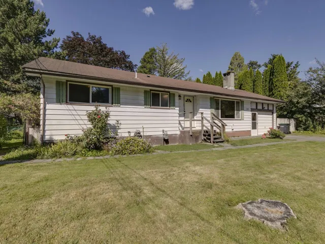 Ranch-style house featuring a chimney and a front lawn