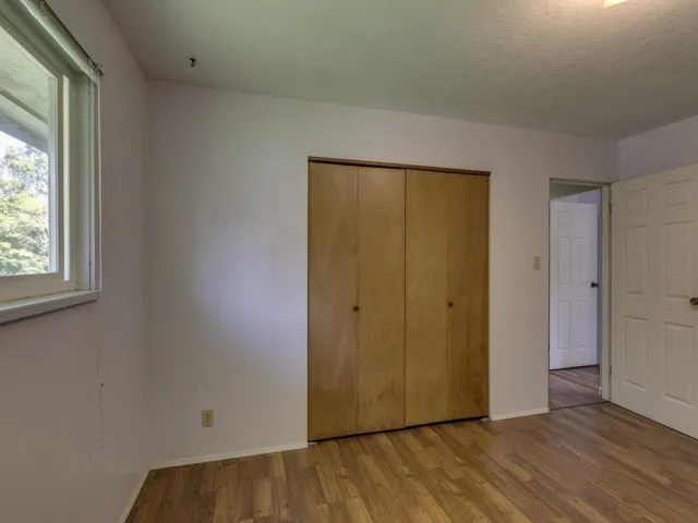 Unfurnished bedroom featuring wood finished floors, a closet, and a textured ceiling