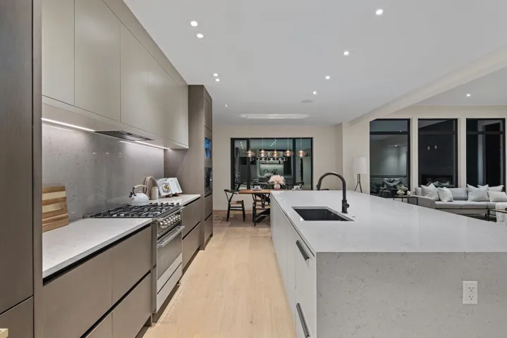 Kitchen with modern cabinets, high end stove, light wood-style flooring, recessed lighting, and light stone countertops