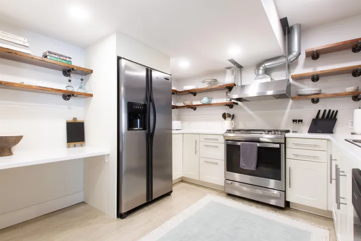 Kitchen featuring stainless steel appliances, wood-finish open shelving, white cabinetry with silver hardware, white countertops, and recessed lighting