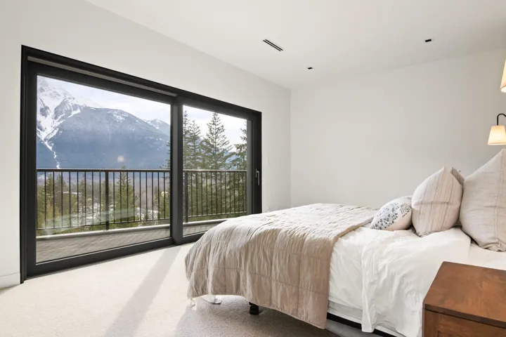 Carpeted bedroom featuring access to exterior, visible vents, and a mountain view
