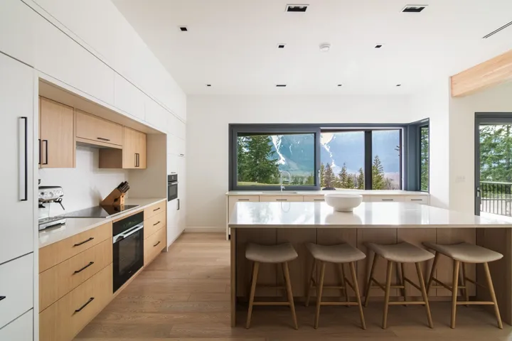 Kitchen featuring modern cabinets, black appliances, and light brown cabinetry