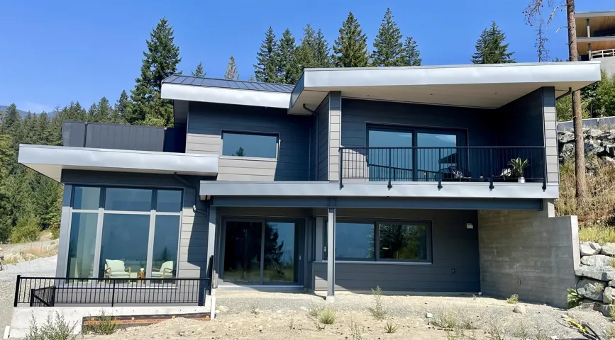 View of front of property featuring a balcony, a standing seam roof, and metal roof
