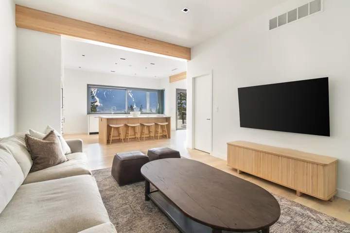 Living room featuring beamed ceiling, baseboards, light wood finished floors, and visible vents