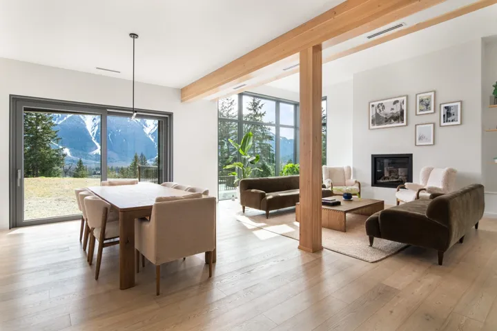 Dining space with beamed ceiling, visible vents, light wood-style floors, and a glass covered fireplace