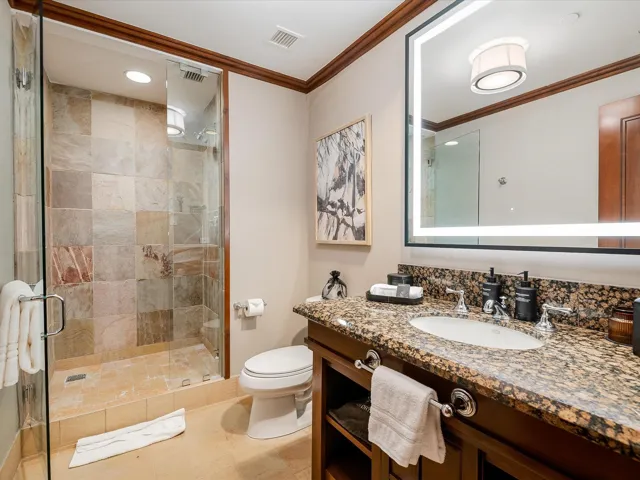 Full bath with ornamental molding, toilet, a stall shower, and visible vents